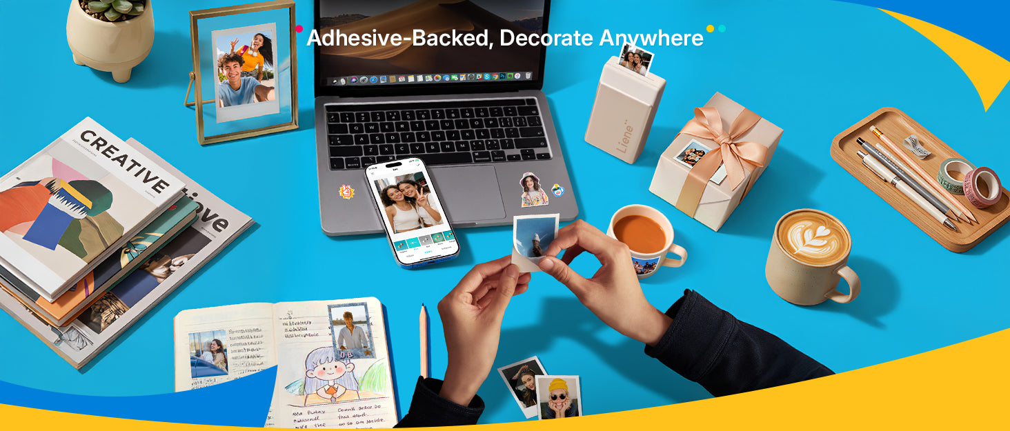 Laptop, phone, and photo frames on a blue background with adhesive-backed decorative items.