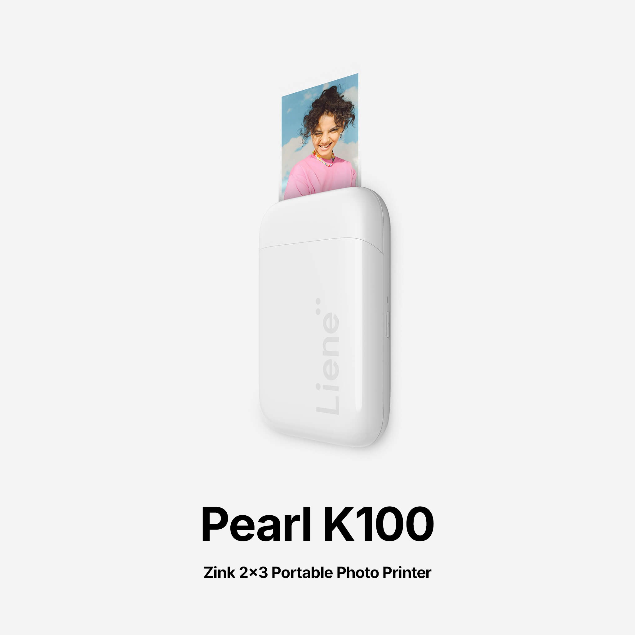 White portable photo printer with a printed photo on a white background